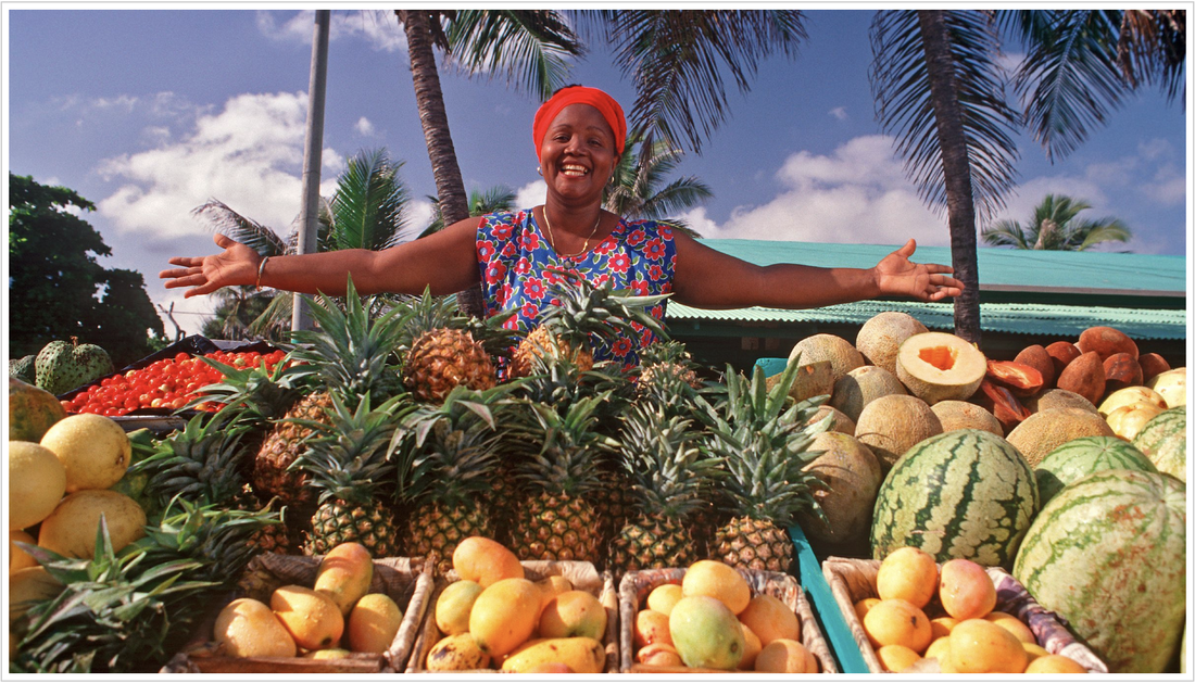 A happy woman selling different fruits at the beach in the Dominican Republic
